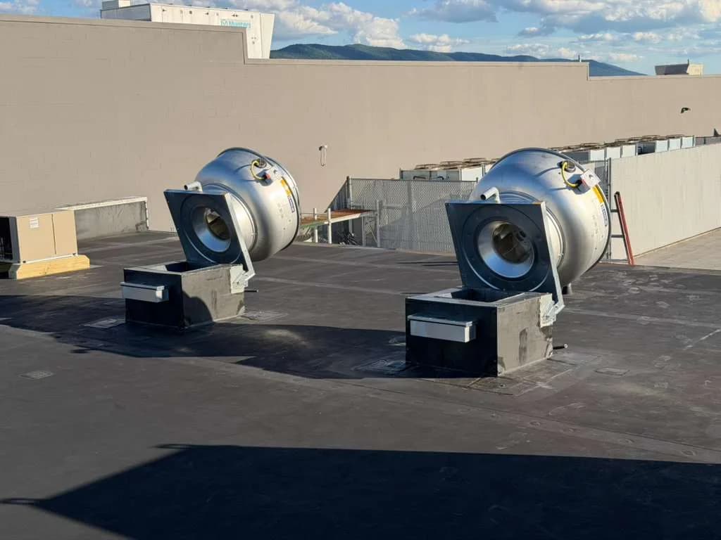 Two CaptiveAire exhaust fans tilted open for inspection on commercial roof