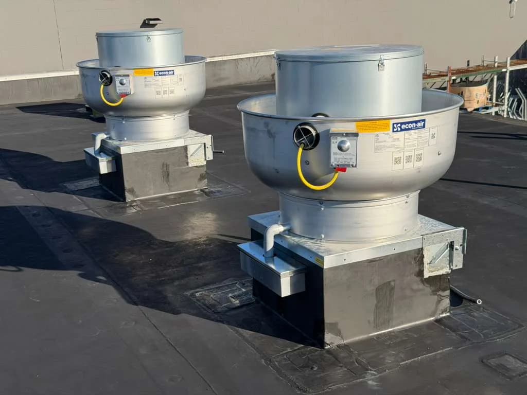 Dual CaptiveAire upblast exhaust fans installed on flat commercial roof